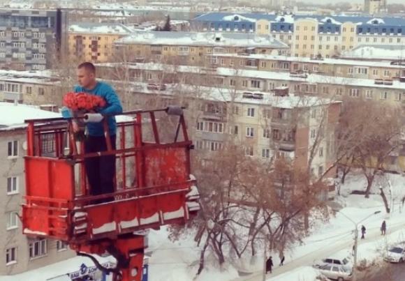 Молодой человек с букетом красных роз поднялся на автовышке в центре Барнаула (видео)